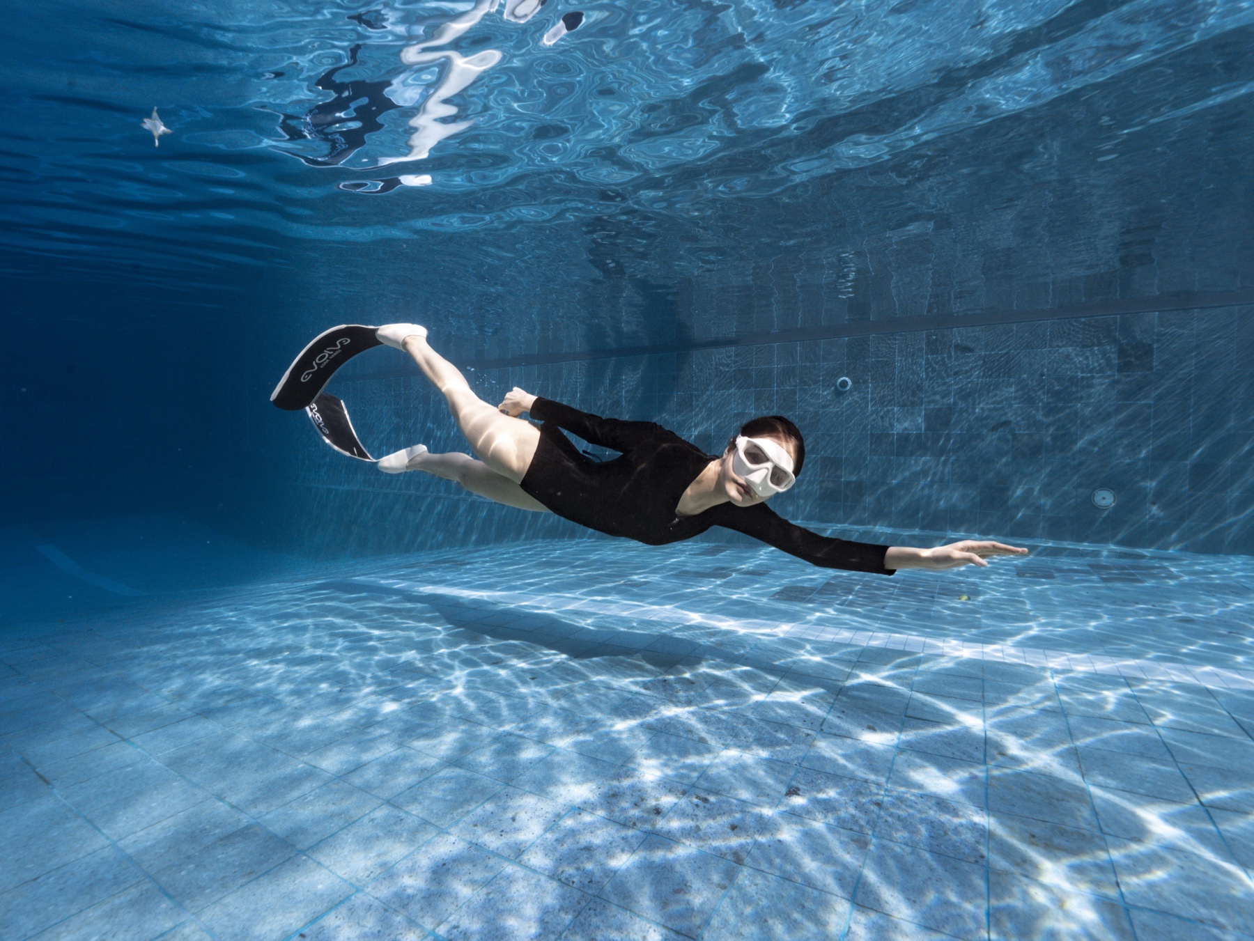 Freediver gliding with control across a clear training pool